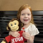 a girl with a stuffed toy monkey